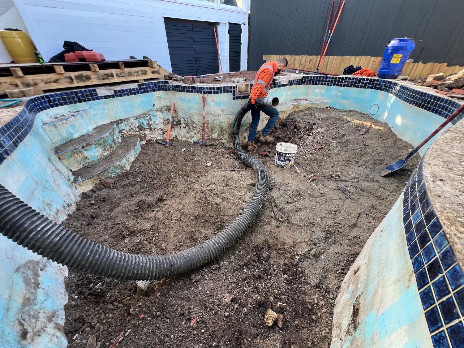 Industrial vacuum cleaning debris from uncovered Mosman pool